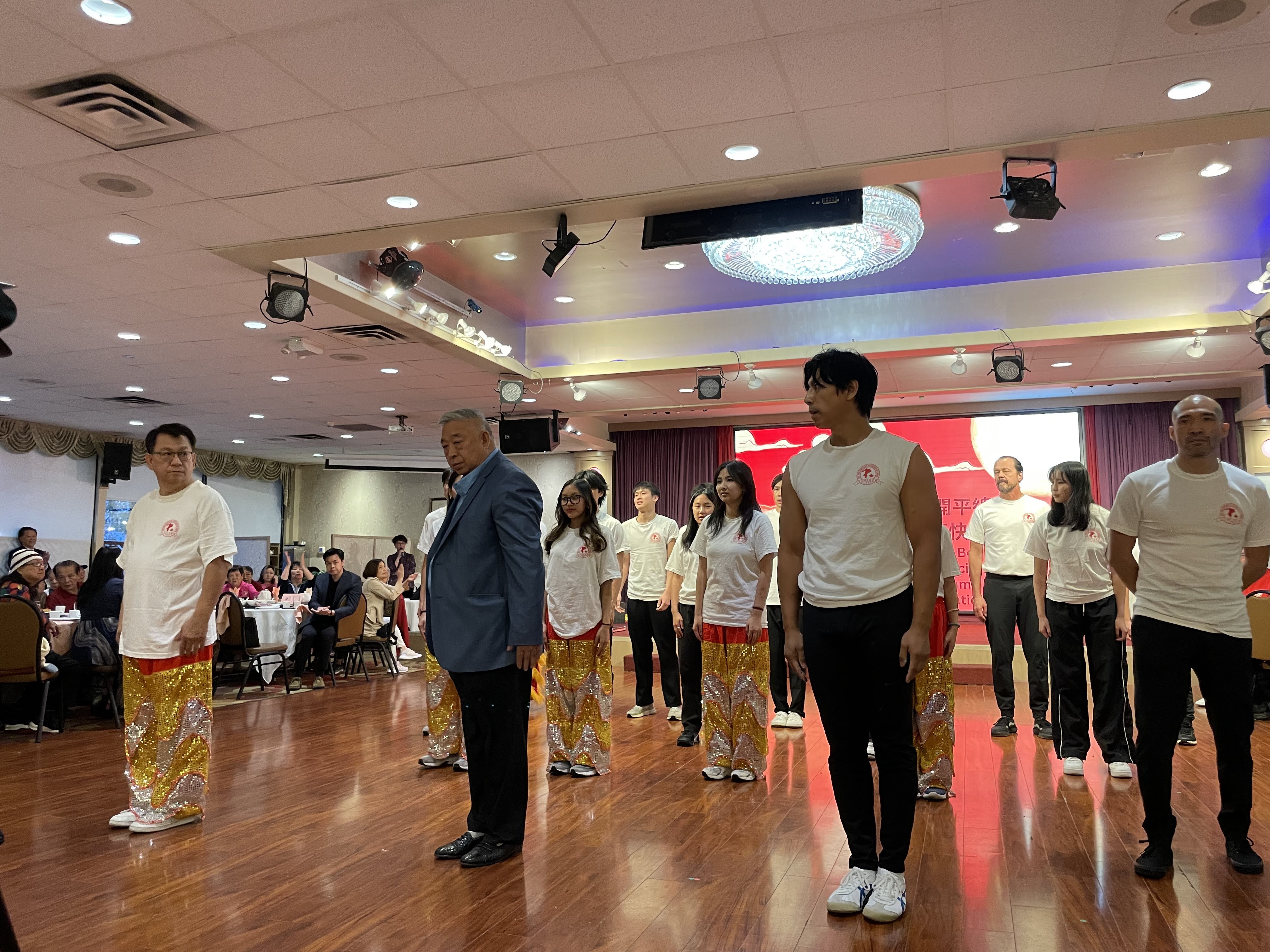 Wide shot of the Hoy Ping Kung Fu team performing lion dance at a community event