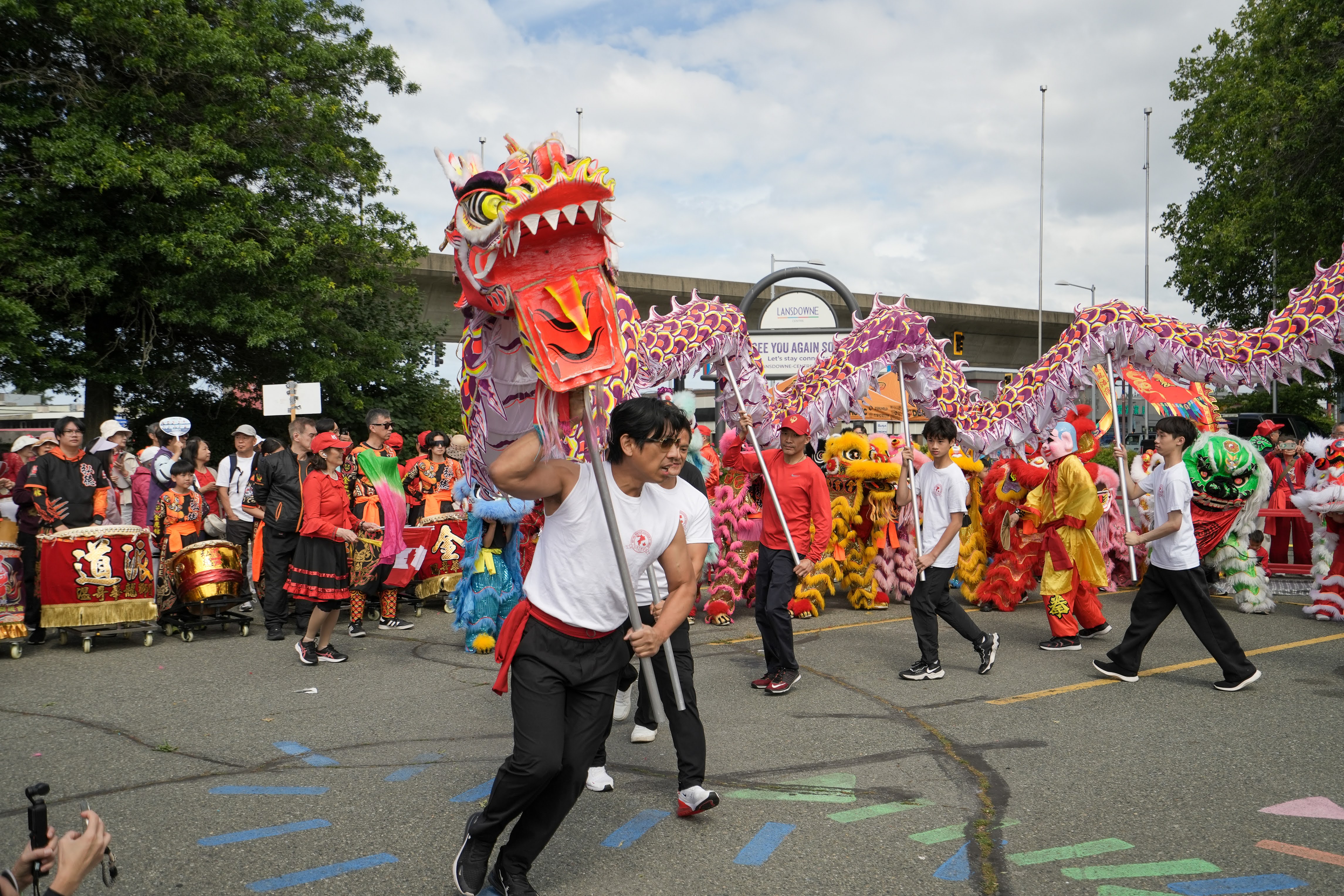 Team of performers holding a long dragon dance figure in motion at an outdoor event