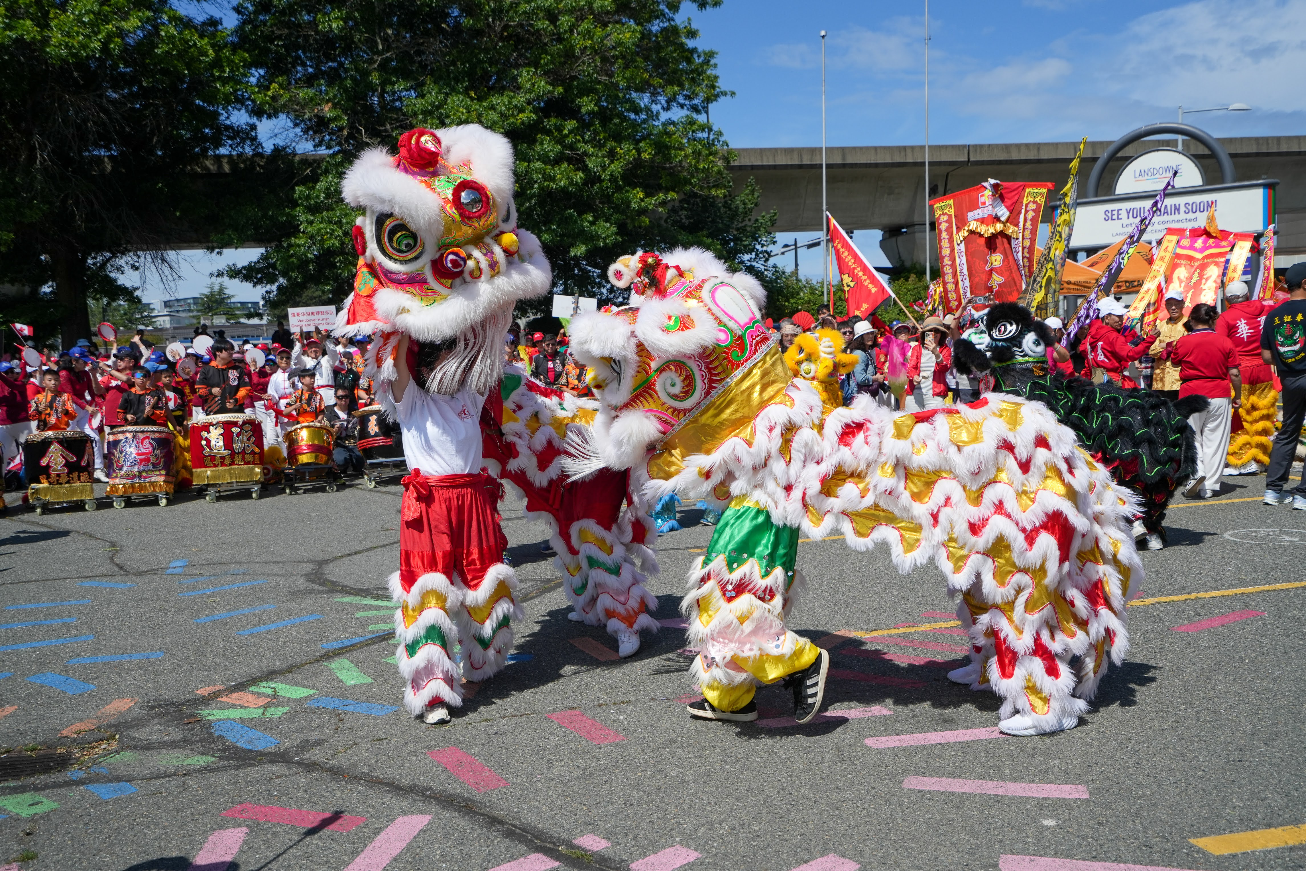 Close-up of a lion dance head with vivid red, gold, and white detailing during a performance